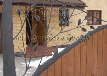 Detal bramy z naturalistycznym motywem gałęzi i liści
