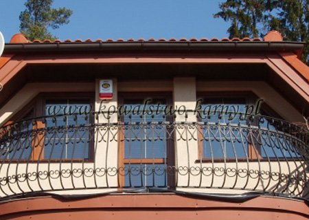 Balkon domu drewnianego z kutą balustradą wybrzuszoną
